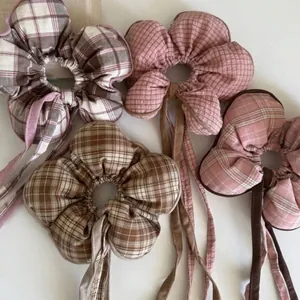 Close-up of checkered flower scrunchies with long ribbons on white background