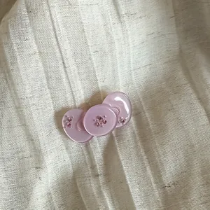 Detail of translucent pink button hair clips with sparkling rhinestone accents