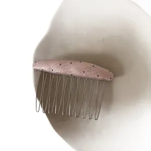 Minimalist pink polka dot hair comb with fabric top and metal teeth for styling