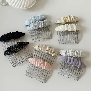 Detailed view of floral mesh and pleated fabric hair combs in multiple sweet colors.