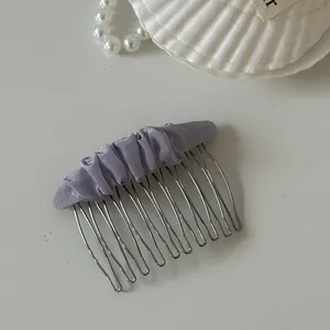 Close-up of lavender mesh fabric detail on silver-toned metal hair comb