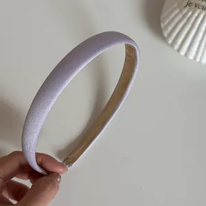 Nahaufnahme eines lavendelfarbenen Satin-Haarreifs mit elegantem, seidigem Finish