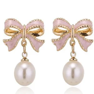 Dettaglio ravvicinato degli orecchini a fiocco in smalto rosa con perle eleganti