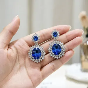 Dettaglio di orecchini di lusso con topazio blu e pavé di cristalli brillanti a cerchio