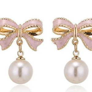 Eleganti orecchini a fiocco in smalto rosa con perle pendenti e finitura dorata