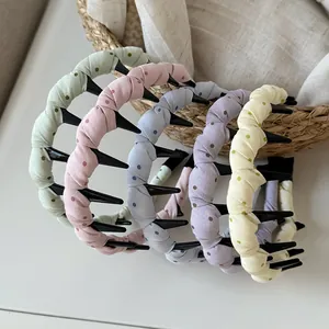 Detail shot of pastel polka dot fabric wrapped wave headbands with long inner teeth.