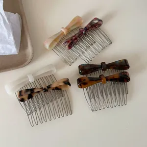 Macro detail of various patterns on acetate bow hair combs with metal teeth