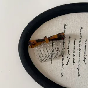 Close-up of tortoise shell acetate bow on a metal hair side comb for women