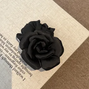 Detailed view of the elegant black fabric rose hair claw clip with satin finish
