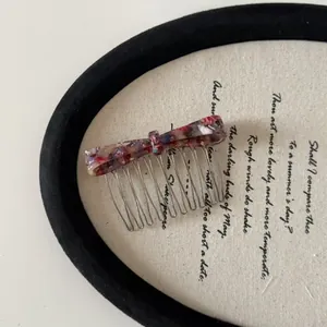 Acetate bow hair comb with floral marble pattern and metal tines for elegant styling