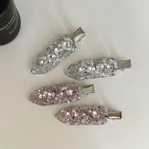 Detailed view of luxury full crystal hair clips with pink diamonds and pearls