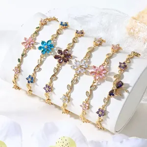 Primo piano di eleganti bracciali placcati oro con fiori e foglie di cristallo colorati