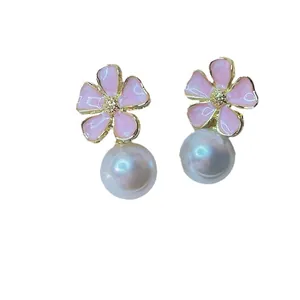 Close-up of pink enamel flower stud earrings with elegant white pearl drops for women
