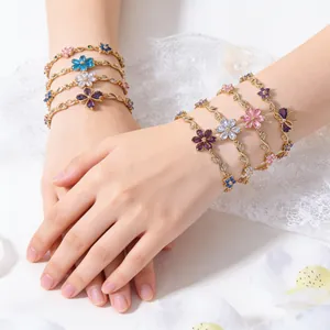 Primo piano di bracciali placcati in oro con fiori a cinque petali in cristallo colorato