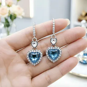 Primo piano di orecchini di cristallo blu a forma di cuore con placcatura argento.
