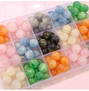 Close-up of colorful resin cat-eye beads in a storage box for DIY jewelry making