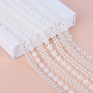Macro view of white ABS pearl floral chains with rhinestones for DIY jewelry making.