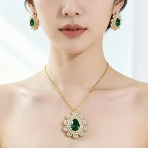 Primo piano di un set di collana e orecchini a goccia verde smeraldo di lusso.