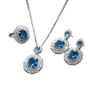 Set di gioielli di lusso in topazio blu con collana anello e orecchini halo su bianco