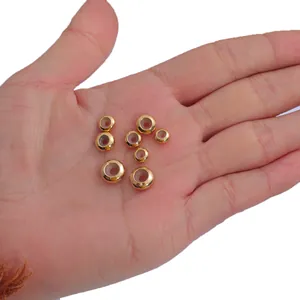 Close-up of 18K gold plated silicone slider beads for jewelry making shown in hand