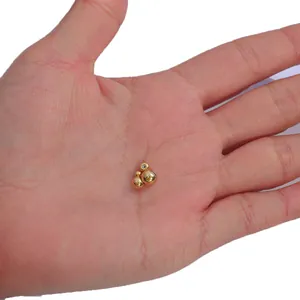 Small 18K gold plated copper silicone stopper beads for DIY jewelry making held in palm