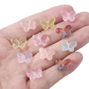 Assorted colorful butterfly shaped glass beads for DIY jewelry making held in hand