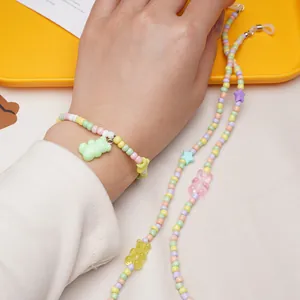 Close-up of pastel beaded bracelet and chain with colorful acrylic gummy bear charms.