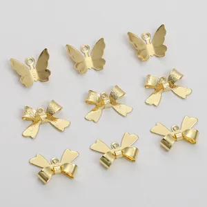 Vista detallada de dijes de mariposa y lazo bañados en oro de 14K para hacer joyas DIY.
