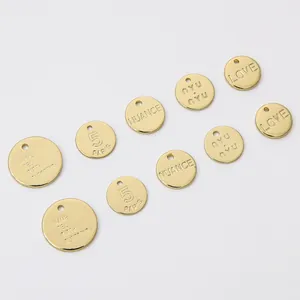 High detail view of 14K gold plated brass circular charms featuring various custom engravings