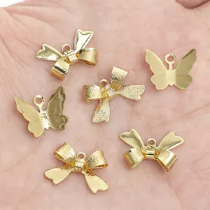 Detalle de colgantes de lazo y mariposa rellenos de oro de 14K para bisutería DIY