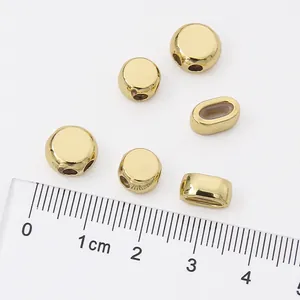 Close-up of 14K gold filled flat round beads with ruler for size reference