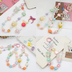 Colorful acrylic beaded phone charms with bows and hat pendants in a detail view