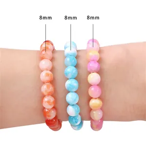 Vista dettagliata di braccialetti di perle di giada persiana sintetica da 8 mm su un polso.