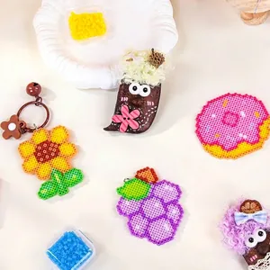 Farbenfrohes DIY-Sicherungsperlen-Set mit Sonnenblumen- und Donut-Bastelarbeiten auf Beige