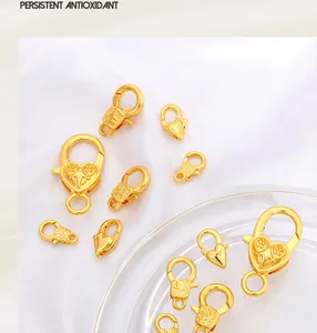 Dettaglio macro di chiusure a moschettone a cuore placcate oro 18K per gioielleria fai-da-te