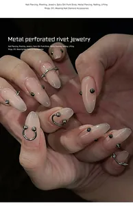Close-up of punk style stainless steel nail piercing rivet jewelry on long nails