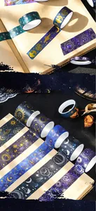 Detailed macro view of dreamlike galaxy washi tapes with gold stamping on a vintage notebook