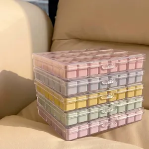 Gestapelde macaron-gekleurde nagelkunst opbergdozen met vakjes op een bank in de zon