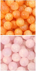 Close-up view of shimmering resin cat eye round beads in orange and pink color options