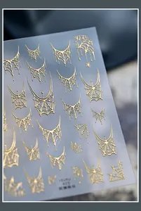 Detailopname van goudkleurige reliëf spinnenweb nagelstickers voor Halloween manicure decoratie.