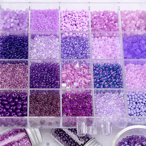 Detailed view of various purple glass seed beads organized in a clear plastic grid box for DIY