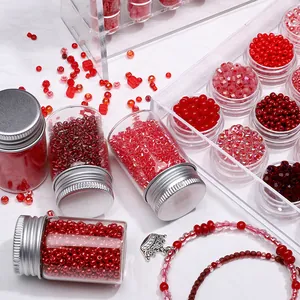 Detailed view of assorted red glass seed beads in glass bottles for DIY jewelry making.