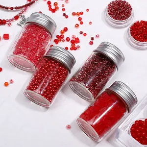 Detail view of assorted red glass seed beads in glass jars for DIY jewelry crafts