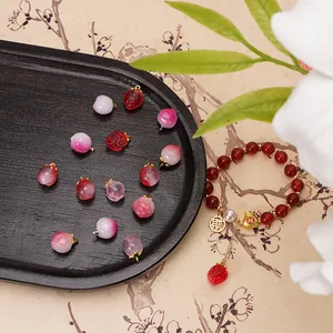 Dettaglio dei ciondoli a forma di pesca e fragola in vetro per la creazione di gioielli fai da te