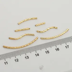 Textured 14K gold filled curved and straight jewelry tubes next to a ruler for scale