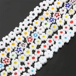 Close-up of colorful flat plum flower Millefiori glass beads arranged in neat rows on black
