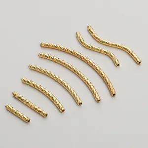 Detailed view of 14K gold plated copper textured tube beads in various curved shapes