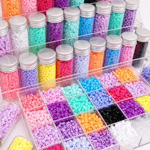 Vue détaillée de perles tubes en acrylique 4mm colorées dans des flacons en verre