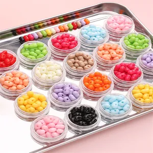 Macro-opname van kleurrijke 8x5mm acryl pindakralen in potjes voor DIY sieraden maken