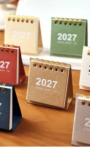 Gros plan de mini calendriers de bureau 2027 en couleurs assorties avec reliure
